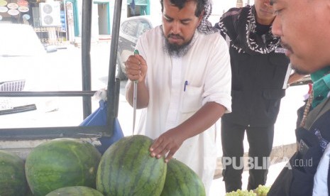 Pedagang semangka di Madinah sedang melayani pembeli, petugas haji Indonesia, Selasa siang (19/9). Satu buah semangka dengan berat rata-rata lima kilogram dijual seharga 10 riyal atau sekitar Rp 35 ribu. 