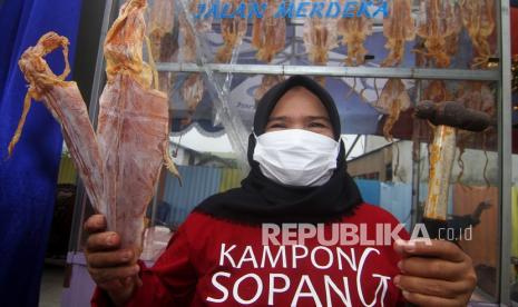 Pedagang Sotong Pangkong memperlihatkan sotong atau cumi kering dan palu yang digunakan untuk mengolah saat Festival Kampong Sotong Pangkong (Sopang) di Jalan Merdeka Barat, Pontianak, Kalimantan Barat, Ahad (11/4/2021). Panganan Sotong Pangkong menjadi jajanan kuliner khas bulan Ramadhan yang banyak dicari dan diminati masyarakat di Kota Pontianak, Provinsi Kalimantan Barat.