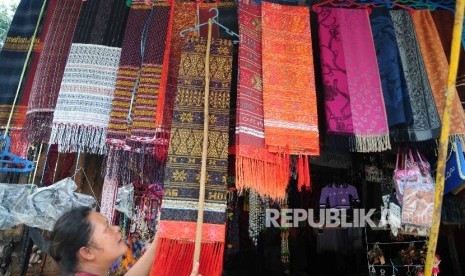 Pedagang souvenir khas Danau Toba melayani wisatawan di Desa Wiata Tomok, Samosir, Sumatra Utara, Senin (22/8).