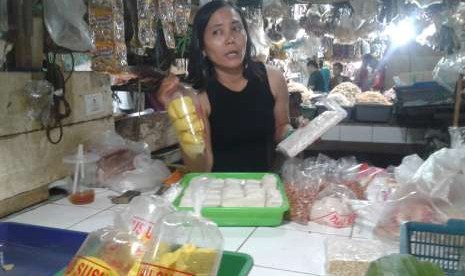 Pedagang tahu dan tempe di Pasar Lenteng, Jakarta Selatan, menunjukkan dagamgannya, Jumat (7/9).