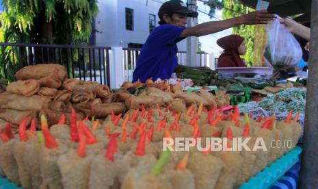 Pedagang takjil atau makanan berbuka puasa melayani pembeli di pasar takjil.