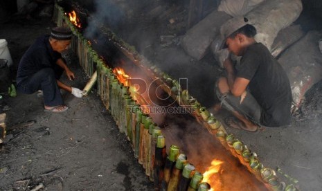  Pedagang tengah memasak Lemang menggunakan kayu bakar di kawasan Kramat, Senen, Jakarta Pusat, Selasa (23/7).    (Republika/Rakhmawaty La'lang)