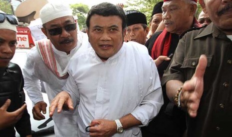   Pedangdut Rhoma Irama (tengah) dikawal pendukungnya ketika memenuhi panggilan Panwaslu DKI Jakarta, Jakarta Pusat, Senin (6/8). 