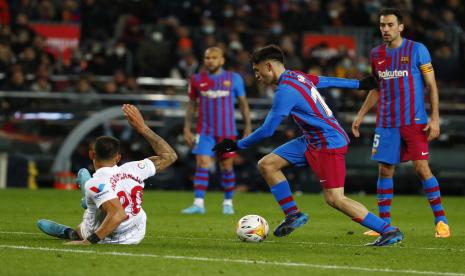 Gelandang Barcelona, Pedri (kanan tengah), mengontrol bola sebelum mencetak gol selama pertandingan sepak bola La Liga Spanyol antara Barcelona dan Sevilla di Stadion Camp Nou di Barcelona, Spanyol, Ahad, 3 April 2022.