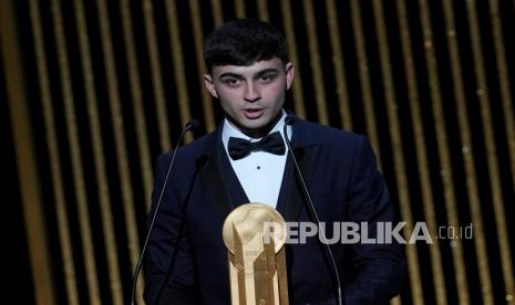 Pedri memegang trofi Kopa Ballon dOr 2021 untuk pemain muda terbaik tahun ini dalam upacara Bola Emas ke-65 di Theatre du Chatelet, di Paris, Selasa (30/11) dini hari WIB.