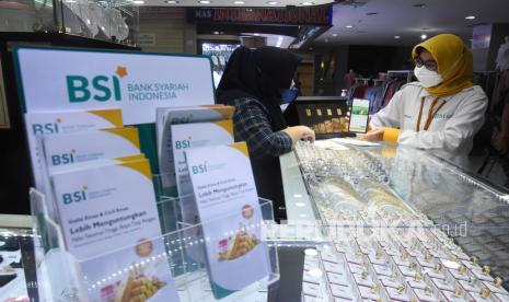 Pegawai Bank Syariah Indonesia (BSI) Kantor Cabang Mayestik menjelaskan fitur gadai dan cicil emas di BSI Mobile Banking kepada nasabah pemilik toko emas pada kegiatan Grebek Pasar BSI di Pasar Mayestik, Jakarta Selatan, Rabu (15/12/2012). PT Bank Syariah Indonesia Tbk (BSI) dorong pertumbuhan pembiayaan gadai dan cicil emas lewat program grebek pasar di 23 titik pasar di wilayah Jakarta yang dikelola oleh PD Pasar Jaya untuk mendukung upaya akselerasi bisnis gadai dan cicil emas BSI. 