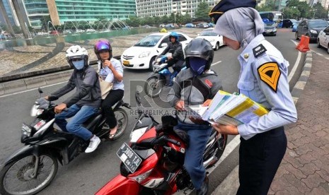  Pegawai kemenhub membagikan peta jalur mudik kepada pengendara di Bundaran HI, Jakarta, Selasa (30/7). (Republika/ Tahta Aidilla)