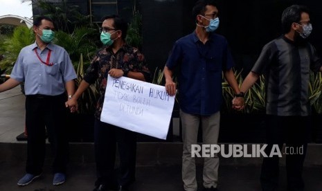 Pegawai Komisi Pemberantasan Korupsi (KPK) menggelar aksi dengan berdiri berjajar melingkari gedung Merah Putih KPK, Kamis (7/2). Mereka meminta kepolisian agar segera menangkap pelaku penganiayaan terhadap penyidik KPK.