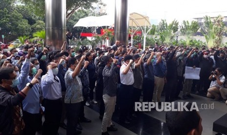 Pegawai Komisi Pemberantasan Korupsi (KPK) menggelar aksi dengan berdiri berjajar melingkari gedung Merah Putih KPK, Kamis (7/2). Mereka meminta kepolisian agar segera menangkap pelaku penganiayaan terhadap penyidik KPK.