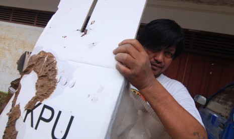    Pegawai KPU Manado membawa kotak suara yang penuh lumpur pasca banjir di kantor KPU Manado, Sulawesi Utara, Senin (20/1).  (Antara/Fiqman Sunandar)