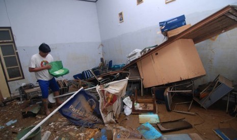 Pegawai KPU mencari dokumen yang masih dapat diselamatkan pasca banjir di kantor KPU Manado, Sulawesi Utara, Senin (20/1). (Antara/Fiqman Sunandar)