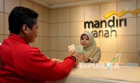 Pegawai Mandiri Syariah tengah melayani nasabah yang melakukan transfer dana ke luar negeri di Bank Mandiri Syariah Cabang Menteng, Jakarta, Selasa (12/9).