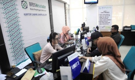 Pegawai melayani peserta Badan Penyelenggara Jaminan Sosial (BPJS) Kesehatan di Kantor BPJS Kesehatan cabang Jakarta Selatan, Rabu (25/11).