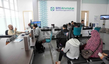 Pegawai melayani peserta Badan Penyelenggara Jaminan Sosial (BPJS) Kesehatan di Kantor BPJS Kesehatan cabang Jakarta Selatan, Rabu (25/11).