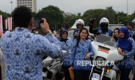 Pegawai negeri sipil melakuka swafoto usai mengikuti upacara peringatan Hari Ulang Tahun ke-45 KORPRI di Lapangan Monumen Nasional, Jakarta, Selasa (29/11)