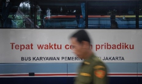 Pegawai Negeri Sipil melintasi armada bus Pemrov DKI di Balaikota, Jakarta Pusat