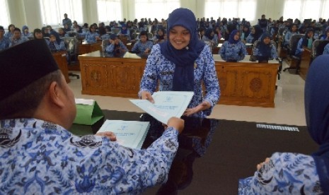 Pegawai Negeri Sipil (PNS) menerima Surat Keputusan (SK) pengangkatan.