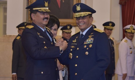 Pejabat baru Kepala Staf TNI Angkatan Udara (KSAU) Marsekal Madya (Marsdya) Hadi Tjahjanto (kiri) berjabatan tangan dengan pejabat lama Marsekal Agus Supriatna (kanan) usai pelantikan di Istana Negara, Jakarta, Rabu (18/1). 