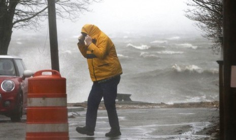 Pejalan kaki berjalan di dekat garis pantai di Newburyport, Massachusetts, Pantai Timur AS di tengah badai, Jumat (2/3). Cuaca buruk yang menerjang AS menyebabkan kekacauan transportasi.