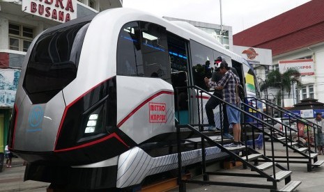 Pejalan kaki melihat purwarupa Light Rail Transit (LRT) Metro Kapsul di pedestrian Alun-alun Bandung, Jawa Barat, Kamis (6/4).