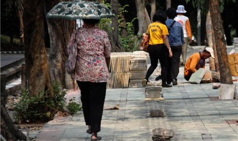  Pejalan kaki melintasi jalur pedestrian yang sedang diperbaiki. (ilustrasi) 