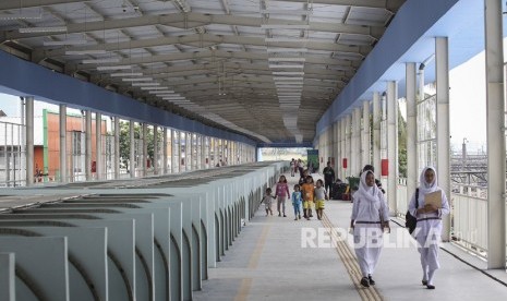 Pejalan kaki melintasi Skybridge atau Jembatan Penyeberangan Multiguna (JPM) Tanah Abang di Jakarta, Jumat (7/12/2018). 