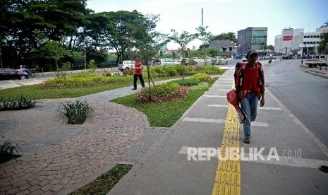 Pejalan kaki melintasi trotoar di Jalan Jatibaru Raya,Tanah Abang, Ahad (8/1).