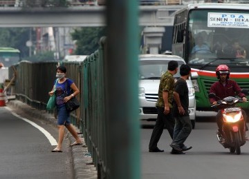 Pejalan kaki menerobos pagar pembatas untuk menyeberang jalan padahal tidak jauh dari lokasi itu terdapat jembatan penyeberangan di sekitar kawasan Senen, Jakarta, Senin (2/1). (Republika/Edwin Dwi Putranto)