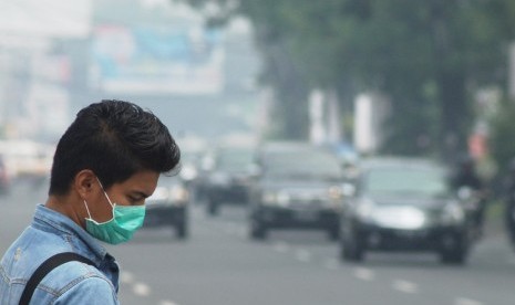 Pejalan kaki menggunakan masker saat melintas di Jalan Pemuda, Padang, Sumbar, Rabu (26/2).