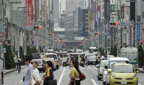 Pejalan kaki menyeberang di distrik perbelanjaan mewah di Ginza, Jepang.