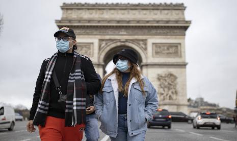 Pejalan kaki yang mengenakan berjalan di Champs-Elysees di pusat kota Paris, Prancis.