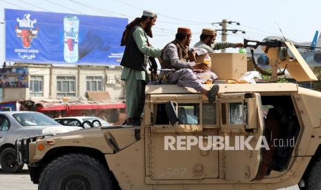 Milisi Taliban berjaga di depan Bandara Internasional Hamid Karzai, di Kabul, Afghanistan, Senin, 16 Agustus 2021. Ribuan orang memadati bandara ibukota Afghanistan pada hari Senin, bergegas ke landasan dan mendorong ke pesawat dalam upaya putus asa untuk melarikan diri negara itu setelah Taliban menggulingkan pemerintah yang didukung Barat.