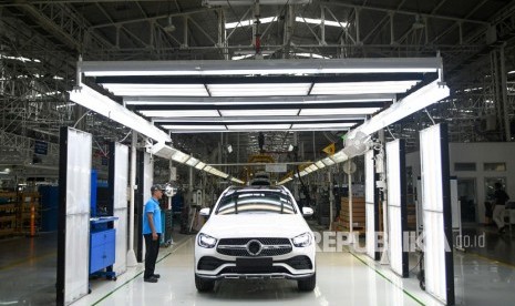 Pekerja berada di samping mobil New GLC Mercedes-Benz yang selesai dirakit di pabrik Mercedes-Benz Indonesia di Wanaherang, Gunung Putri, Bogor, Jawa Barat, Selasa (10/12/2019).