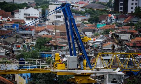 Pekerja beraktivitas di atas crane proyek pembangunan rumah deret, Tamansari, Bandung, Jawa Barat.