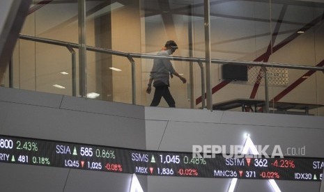 Pekerja beraktivitas di atas layar pergerakan Indeks Harga Saham Gabungan (IHSG) di gedung Bursa Efek Indonesia, Jakarta, Jumat (5/4/2019).