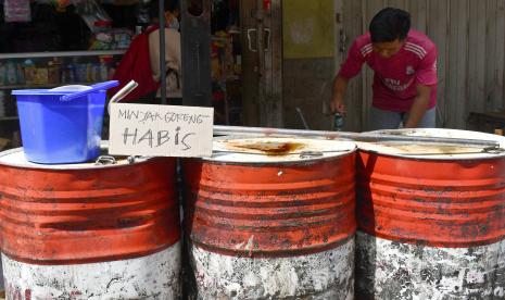 Pekerja beraktivitas di dekat drum kosong tempat minyak goreng curah di toko tradisional Pasar Caruban Baru, Madiun, Jawa Timur, Senin (21/3/2022). Menurut keterangan sejumlah pemilik toko tradisional stok minyak goreng curah di pasar tersebut kosong sejak seminggu terakhir karena tak adanya pasokan, sedangkan minyak goreng kemasan mengalami kelangkaan dengan stok terbatas yang dijual Rp23 ribu per liter. 