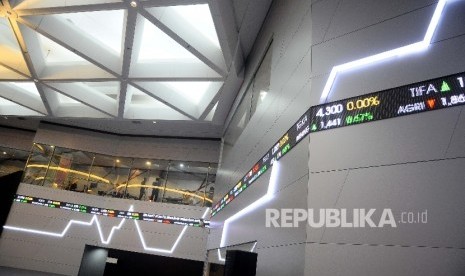 Pekerja berdiri didekat layar pergerakan Indeks harga Saham gabungan (IHSG), Gedung Bursa Efek Indonesia, Jakarta. ilustrasi