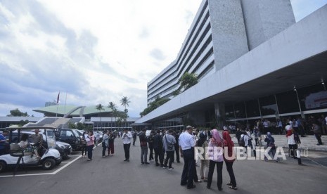 Pekerja berhamburan keluar Gedung Nusantara III saat merasakan gempa di Kompleks Parlemen, Senayan, Jakarta, Selasa (23/1).