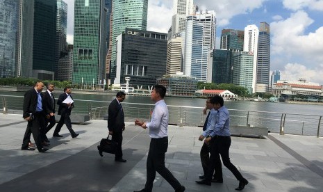 Pekerja berjalan di kawasan distrik finansial Marina Bays Singapura.