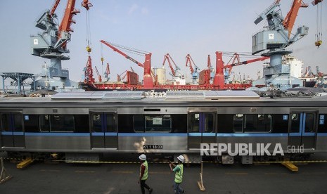 Pekerja berjalan di samping gerbong kereta MRT di Tempat Penimbunan Sementara (TPS) dermaga 101, Pelabuhan Tanjung Priok, Jakarta, Kamis (5/4). 