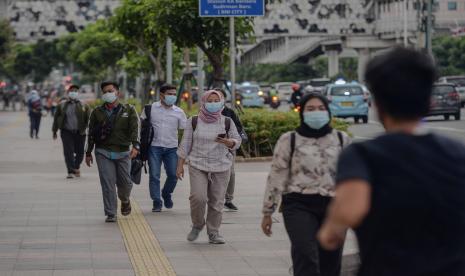 Pekerja berjalan saat jam pulang kerja di kawasan bisnis Sudirman-Thamrin, Jakarta.