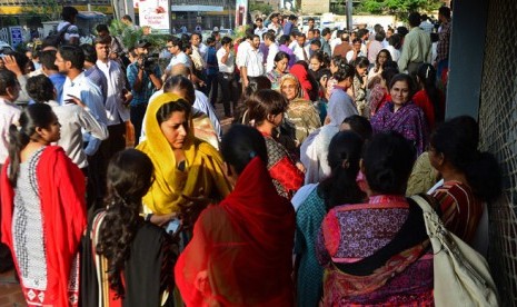 Pekerja dan pejalan kaki meninggalkan gedung setelah gempa mengguncang Pakistan