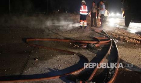 Pekerja dan petugas kepolisian berjaga di sekitar lokasi tempat kejadian pipa gas yang bocor milik PT. Chevron Pacific Indonesia di jalan lintas Duri - Pekanbaru kilometer 121 Desa Balai Raja Pinggir, Bengkalis, Riau, Senin (17/9). 