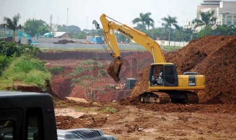 Pekerja dan sebuah alat berat kembali menyelesaikan pembangunan tunnel underpass tol Cijago di Jalan Margonda Raya, Depok, Jumat (27/6).