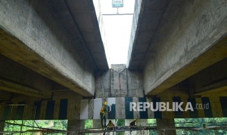 Pekerja dari Jasa Marga memperbaiki retakan pada pilar jembatan Cisomang Jalan Tol Pubaleunyi KM 100 akibat pergeseran, perbatasan Kabupaten Bandung Barat dan Kabupaten Purwakarta, Jumat (23/12).