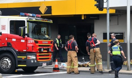 Pekerja darurat berada kantor cabang Commonwealth Bank of Australia, Melbourne dimana seorang pria membakar dirinya, Jumat (18/11). 