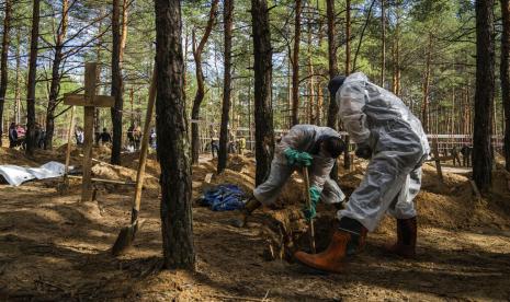 Pekerja darurat menggali kuburan seorang warga sipil selama penggalian di daerah Izium yang baru saja direbut kembali, Ukraina, Sabtu, 17 September 2022. Pihak berwenang Ukraina menemukan situs pemakaman massal di dekat kota Izium yang direbut kembali yang berisi ratusan kuburan. Tidak jelas siapa yang dimakamkan di banyak plot atau bagaimana semuanya mati, meskipun saksi dan penyelidik Ukraina mengatakan beberapa ditembak dan yang lain terbunuh oleh tembakan artileri, ranjau atau serangan udara.