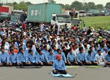 Pekerja demonstrasi melakukan aksi blokir jalan tol Jakarta-Cikampek, Cibitung, Jawa Barat, Jumat (27/1).  (Republika/Tahta Adilla)