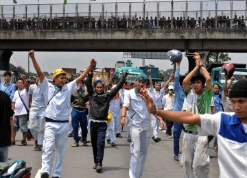 Pekerja demonstrasi melakukan aksi blokir jalan tol Jakarta-Cikampek, Cibitung, Jawa Barat, Jumat (27/1).  (Republika/Tahta Aidilla)