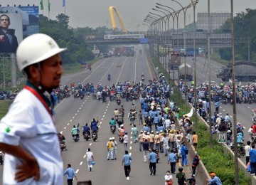 Pekerja demonstrasi melakukan aksi blokir jalan tol Jakarta-Cikampek, Cibitung, Jawa Barat, Jumat (27/1).  (Republika/Tahta Aidilla)